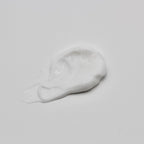 White cream smear on a light gray background