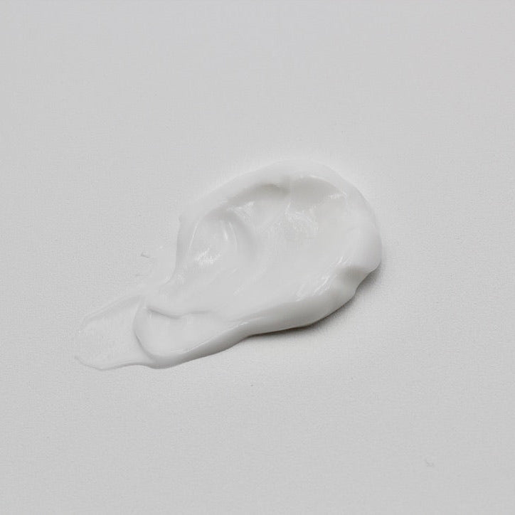 White cream smear on a light gray background