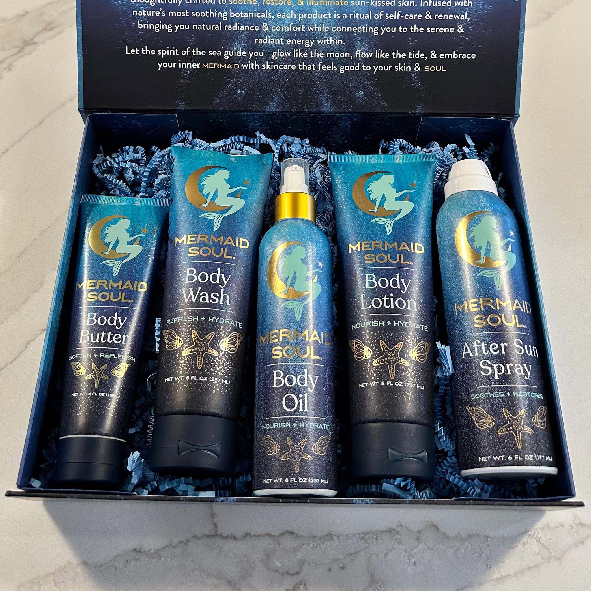 Set of Mermaid Soul skincare products in a decorative box on a marble surface.