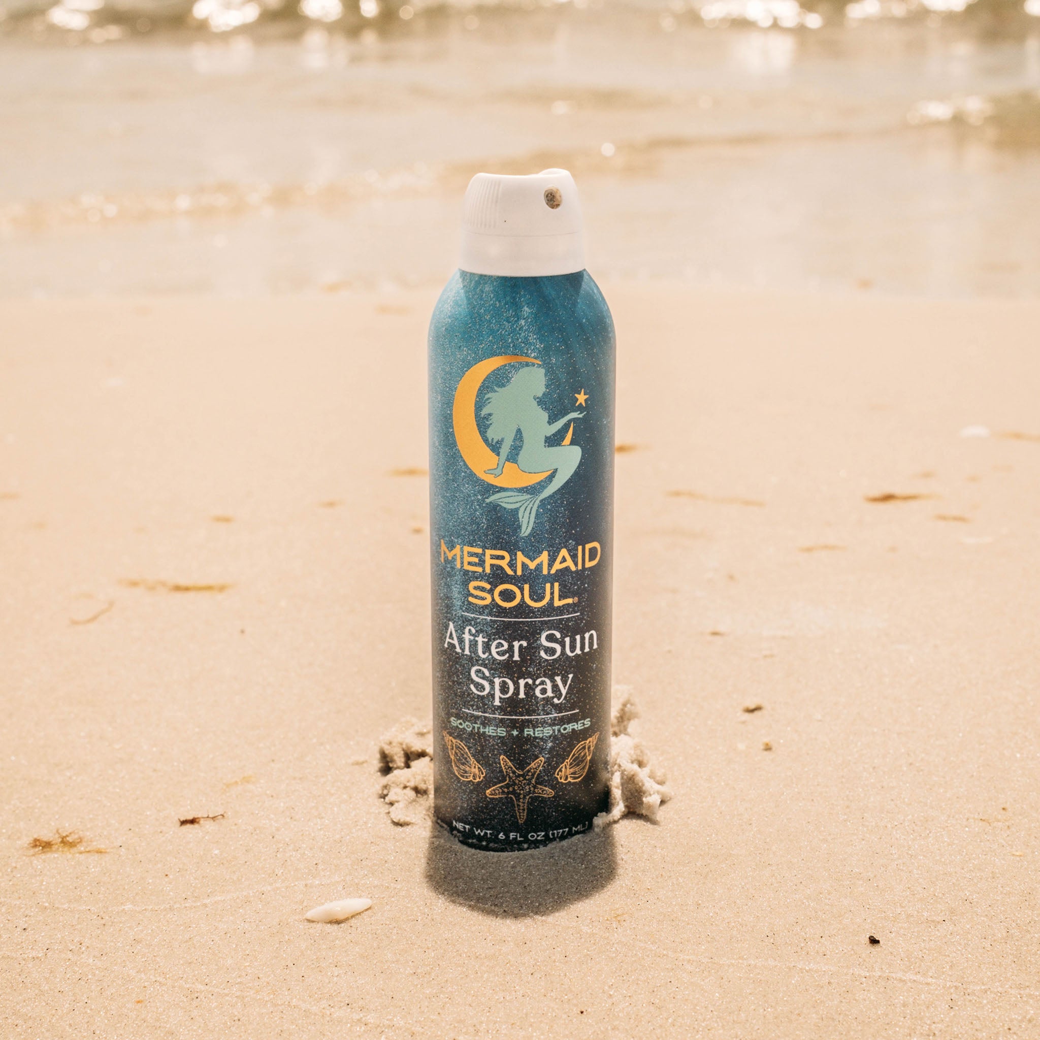 Mermaid Soul After Sun Spray bottle on a sandy beach