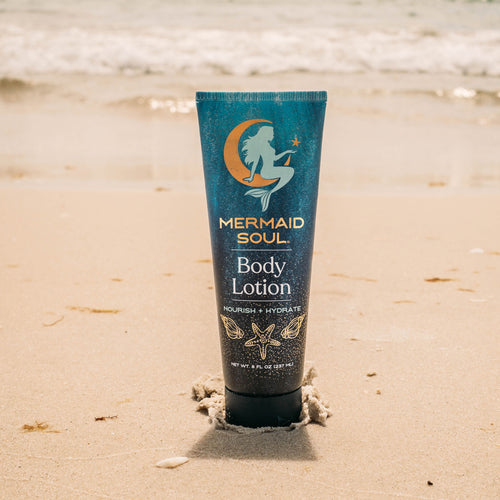 Mermaid Soul body lotion tube on a sandy beach