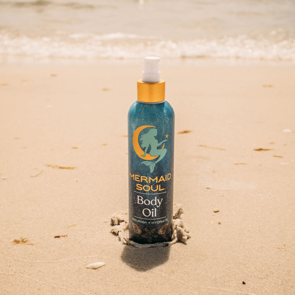 Mermaid Soul body oil bottle on a sandy background