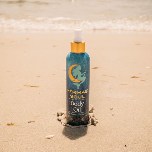 Mermaid Soul body oil bottle on a sandy background