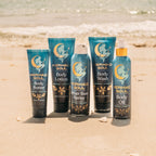 Collection of Mermaid Soul body care products on a sandy beach.